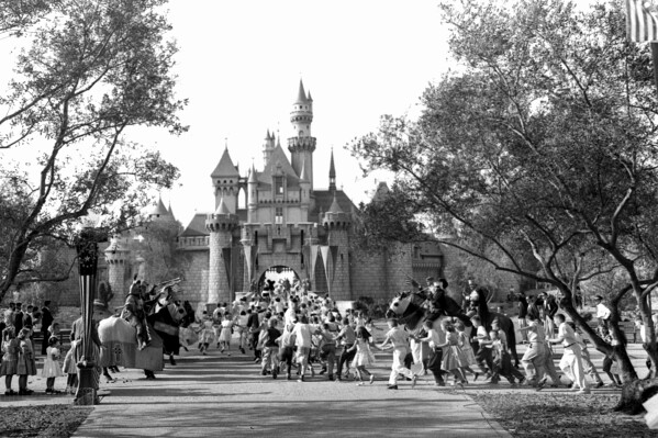 FILE - In this Sunday, July 17, 1955 file photo, children sprint across a drawbridge and into a castle that marks the entrance to Fantasyland at the opening of Walt Disney's Disneyland in Anaheim, Calif. Fantasyland had been closed until late in the day. (ĢӰԺ Photo)