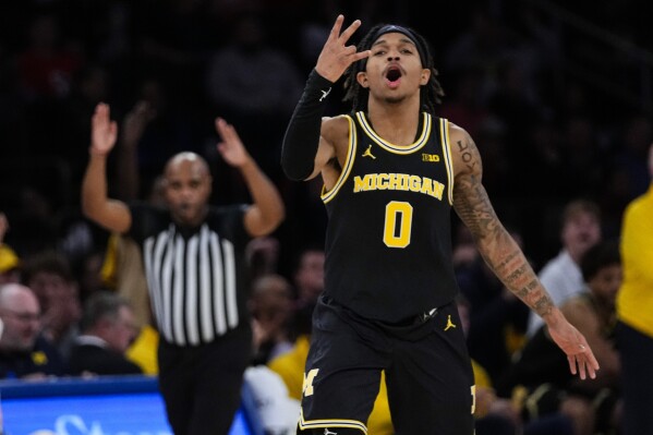 Michigan's Dug McDaniel (0) gestures after making a three-point shot during the second half of an NCAA college basketball game against St. John's Monday, Nov. 13, 2023, in New York. (AP Photo/Frank Franklin II)