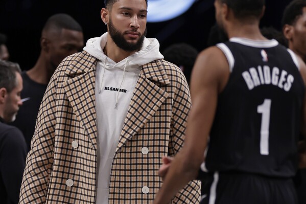 Brooklyn Nets guard Ben Simmons greets Mikal Bridges (1) walking to the bench against the Miami Heat during the first half of an NBA basketball game, Saturday, Nov. 25, 2023, in New York. (AP Photo/Adam Hunger)