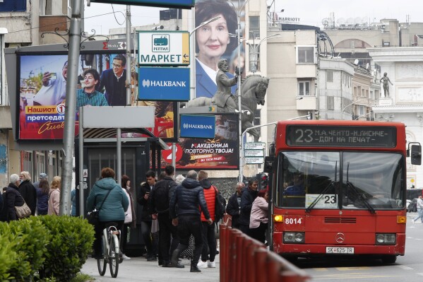 Election posters of Stevo Pendarovski, incumbent President and a presidential candidate backed by the ruling social democrats (SDSM), left and Gordana Siljanovska Davkova, a presidential candidate supported by the center-right main opposition VMRO-DPMNE coalition, center top, are pictured in a busy street in Skopje, North Macedonia, on Monday April 22, 2024. Voters go to the polls in North Macedonia on Wednesday April 24 for the first round of presidential elections, the seventh such election since the Balkan country gained independence from the former Yugoslavia in 1991, where seven candidates are vying for the largely ceremonial position. (AP Photo/Boris Grdanoski)
