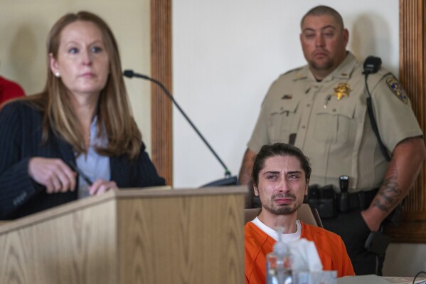 FILE - Ryan Martinez, seated, cries during his preliminary and detention hearing in Tierra Amarilla, N.M., Friday, Oct. 13, 2023, as his attorney Nicole Moss, describes the events that led to him allegedly shooting Jacob Johns during a rally outside the Rio Arriba County Complex in Espanola. An appeals court Monday, Nov. 20, has upheld a judge’s decision to deny bail to Martinez who is charged with attempted murder in the September shooting of a Native American activist during confrontations about canceled plans to reinstall a statue of a Spanish conquistador. Martinez has pleaded not guilty to the charges. (Eddie Moore/The Albuquerque Journal via AP, File)