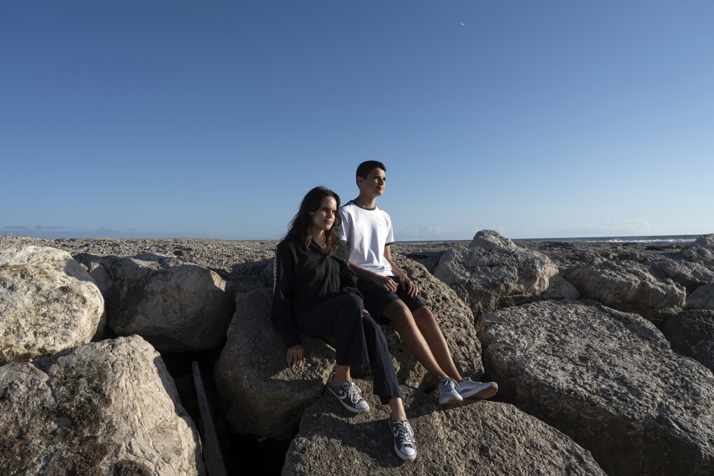 Siblings Sofia Oliveira, 18, and Andre Oliveira, 15, pose for a picture at the beach in Costa da Caparica, south of Lisbon, Wednesday, Sept. 20, 2023. They are two of the six Portuguese children and young adults set to take 32 European governments to court on Wednesday, Sept. 27, for what they say is a failure to adequately address human-caused climate change in a violation of their human rights. (AP Photo/Ana Brigida)