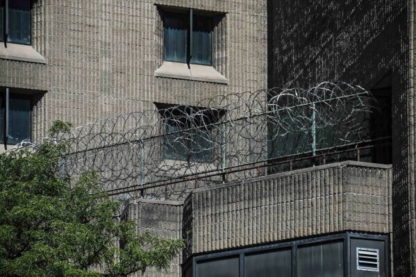 FILE - This Aug. 10, 2019, shows razor wire fencing at the Metropolitan Correctional Center in New York. Democratic lawmakers are raising questions about the federal Bureau of Prisons’ release of high-profile inmates and are calling for widespread testing of federal inmates as the number of coronavirus cases has exploded in the federal prison system. (AP Photo/Bebeto Matthews, File)