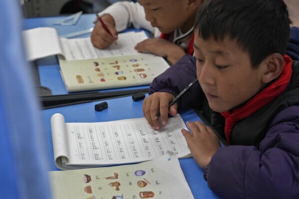 Tibetan students learn Tibetan writing in a first-grade class at the Shangri-La Key Boarding School during a media-organized tour in Dabpa county, Kardze Prefecture, Sichuan province, China on Sept. 5, 2023. A government official from China's Tibetan region on Friday, Nov. 10, 2023 rejected allegations of forced assimilation and curbs on religious freedom, while stressing that Tibetan Buddhism should adapt to the Chinese context. (AP Photo/Andy Wong)