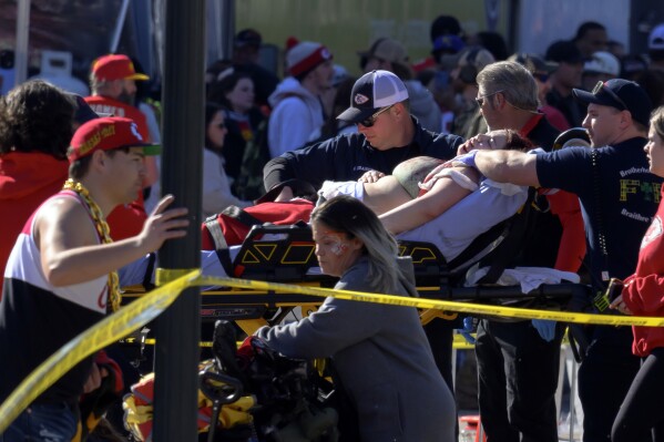 FILE - A woman is rushed to an ambulance following a shooting at the Kansas City Chiefs NFL football Super Bowl celebration in Kansas City, Mo., Wednesday, Feb. 14, 2024. (AP Photo/Reed Hoffmann, File)