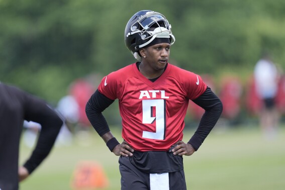 Atlanta Falcons first round draft pick quarterback Michael Penix Jr., takes a quick break during an NFL rookie minicamp football practice Friday, May 10, 2024, in Flowery Branch, Ga. (AP Photo/John Bazemore)