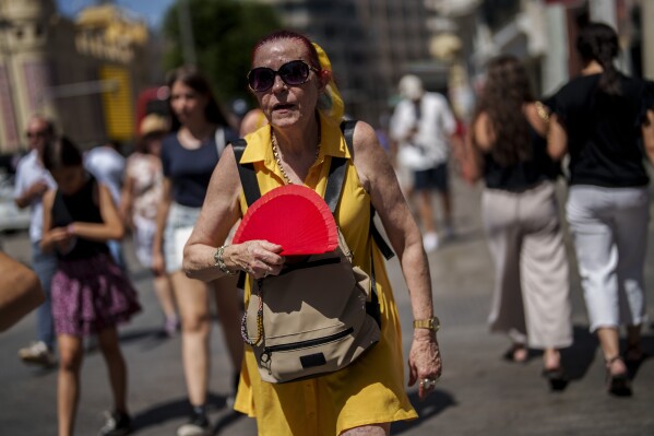 A woman fans herself in Madrid, Spain, Monday, July 10, 2023. (AP Photo/Manu Fernandez)