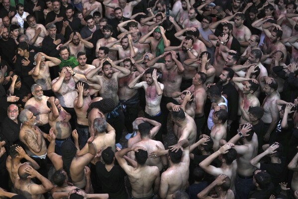 Iranian and Iraqi Shiite Muslims beat their heads and chests during the Ashoura mourning ritual, Friday, July 28, 2023, in Tehran, Iran. Millions of Shiite Muslims around the world on Friday commemorated Ashoura, a remembrance of the 7th-century martyrdom of the Prophet Muhammad's grandson, Hussein, that gave birth to their faith. (AP Photo/Vahid Salemi)