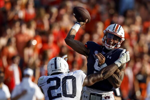 Auburn quarterback Robby Ashford (9) is hit by Penn State defensive end Adisa Isaac (20) as he throws the ball during the second half of an NCAA college football game, Saturday, Sept. 17, 2022, in Auburn, Ala. (AP Photo/Butch Dill)