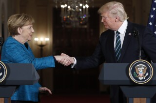 FILE - President Donald Trump and German Chancellor Angela Merkel shake hands following their joint news conference in the East Room of the White House in Washington, Friday, March 17, 2017. (AP Photo/Pablo Martinez Monsivais, File)