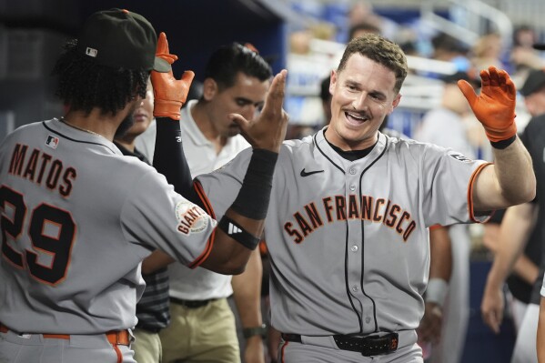 San Francisco Giants' Matt Chapman, right, reacts after hitting a solo home run during the fourth inning of a baseball game against the Miami Marlins, Friday, May 30, 2025, in Miami. (AP Photo/Lynne Sladky)