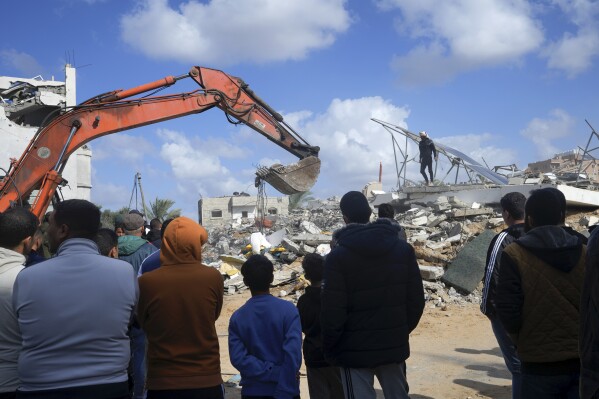 Palestinians search for the bodies of the Darwesh family killed in the Israeli bombardment of the Gaza Strip in Nusseirat refugee camp, central Gaza Strip, Monday, Nov. 20, 2023. (AP Photo/Adel Hana)