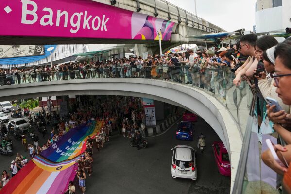 LGBTQ+ community members hold a rainbow flag in its Pride Parade in Bangkok, Thailand, Sunday, June 1, 2025. (AP Photo/Sakchai Lalit)