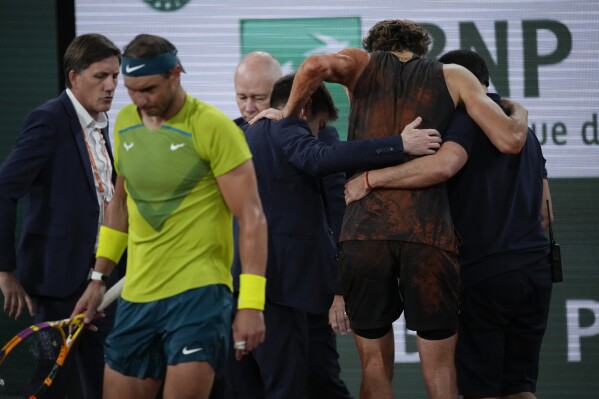 FILE - Germany's Alexander Zverev is carried off the court after twisting his ankle during the semifinal match against Spain's Rafael Nadal, left, at the French Open tennis tournament in Roland Garros stadium in Paris, France, Friday, June 3, 2022. Rafael Nadal is in the French Open field, after all, and the 14-time champion was set up for a challenging first-round matchup in Thursday’s draw against Alexander Zverev. (AP Photo/Christophe Ena)