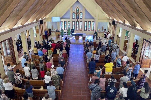 Parishioners attend Mass at Sacred Hearts Mission Church in Kapalua, Hawaii, Sunday, Aug. 13, 2023. Sacred Hearts Mission Church hosted congregants from Maria Lanakila Catholic Church in Lahaina, including several people who lost family members in fires that burned most of the Maui town days earlier. (AP Photo/Haven Daley)