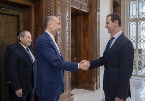 In this photo released on the official Telegram page of the Syrian Presidency, Syrian President Bashar Assad, right, welcomes Iranian Foreign Minister Hossein Amirabdollahian before their meeting in Damascus, Syria, Monday, April 8, 2024. Iran's foreign minister Monday accused the United States of giving Israel the "green light" to strike its consulate building in Syria that killed seven Iranian military officials including two generals. (Syrian Presidency Telegram page via AP)