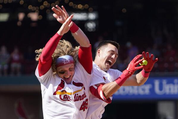 St. Louis Cardinals Harrison Bader removes his batting gloves after lining  out against the Detroit