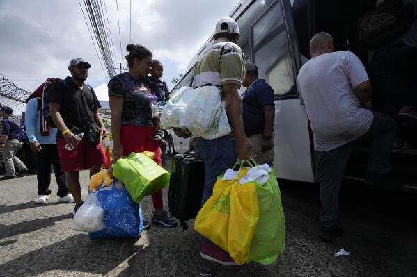 Venezuelan migrants board a bus to the Tocumen International Airport to return to Venezuela, in Panama City, Wednesday, Oct. 26, 2022. (AP Photo/Arnulfo Franco)