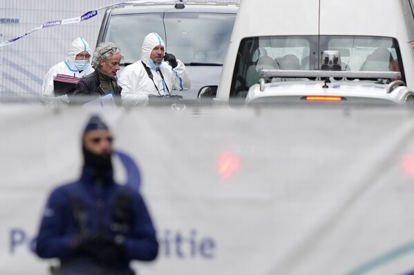 Belgian Police forensic officers work behind a cordoned off area close to where a suspected Tunisian extremist has been shot dead hours after manhunt looking for him Tuesday, Oct. 17, 2023. Police in Belgium have shot dead a suspected Tunisian extremist accused of killing two Swedish soccer fans in a brazen attack on a Brussels street before disappearing into the night on Monday. (AP Photo/Martin Meissner)