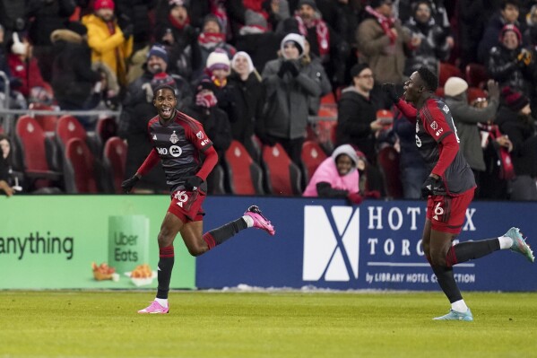 Toronto FC defender Tyrese Spicer (16) celebrates his goal against Atlanta United with teammate Aime Mabika (6) during the first half of a MLS soccer match in Toronto on Saturday, March 23, 2024. (Arlyn McAdorey/The Canadian Press via AP)