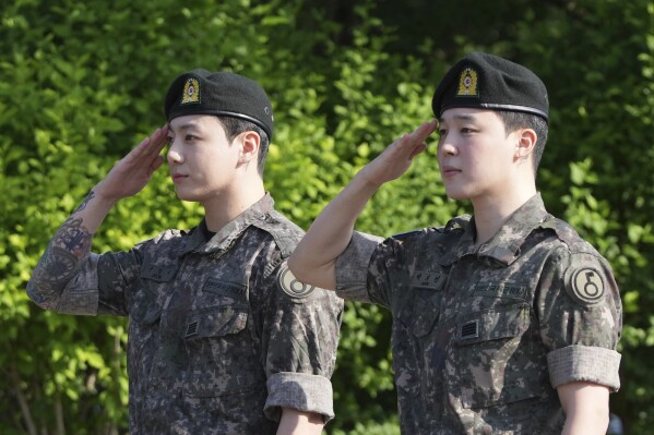 K-pop band BTS members Jimin, right, and Jung Kook salute after being discharged from a mandatory military service in Yeoncheon, South Korea, Wednesday, June 11, 2025. (AP Photo/Lee Jin-man)
