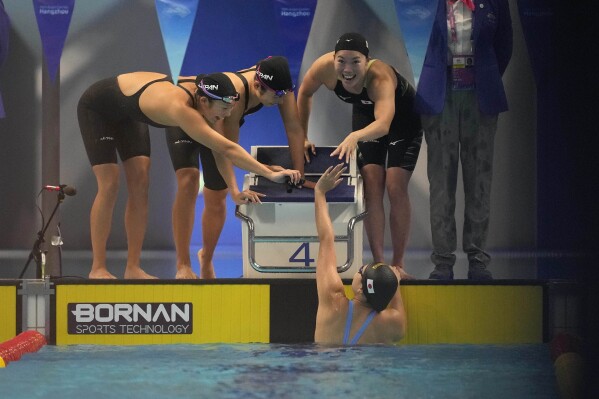 Team Japan celebrates after winning gold in the women's 4x100m Medley Relay final at the 19th Asian Games in Hangzhou, China, Friday, Sept. 29, 2023. (AP Photo/Aaron Favila)