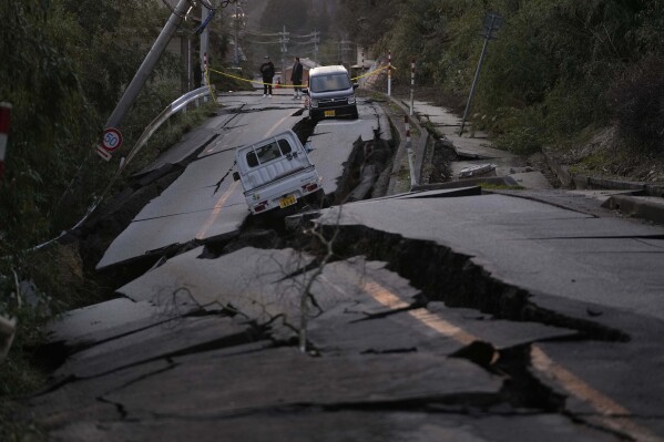 Os visitantes observam os danos perto da cidade de Noto, na Península de Noto, que enfrenta o Mar do Japão, a noroeste de Tóquio, na terça-feira, 2 de janeiro de 2024, após o terremoto devastador de segunda-feira.  (Foto AP/Hiro Gome)