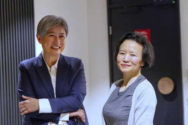 In this photo provided by the Department of Foreign Affairs and Trade, Chinese Australian journalist Cheng Lei, right, poses with Australia's Minister for Foreign Affairs, Penny Wong, at Tullamarine Airport in Melbourne, on Wednesday Oct. 11, 2023. Cheng, who was convicted on murky espionage charges and detained in China for three years has returned to Australia. (Sarah Hodges/DFAT via AP)