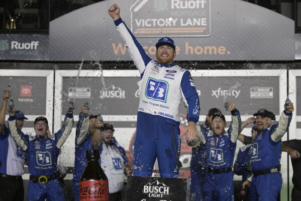 Chris Buescher, center, celebrates in Victory Lane with his crew members after winning a NASCAR Cup Series auto race at Daytona International Speedway, Saturday, Aug. 26, 2023, in Daytona Beach, Fla. (AP Photo/Phelan M. Ebenhack)