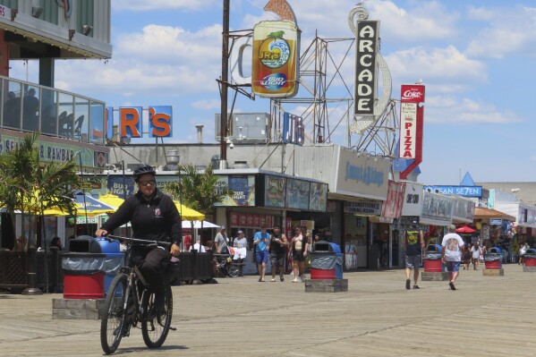 A police officer on a bicycle patrols the boardwalk in Seaside Heights, N.J., Friday, May 31, 2024. On Friday, New Jersey Attorney General Matt Platkin blamed the city of Wildwood, N.J. for not assigning enough police officers to patrol its boardwalk over the Memorial Day weekend when crowds of rowdy teens and young adults overwhelmed the city's capability to respond to disturbances, forcing the boardwalk to be shut down overnight on Sunday, May 26. (AP Photo/Wayne Parry)
