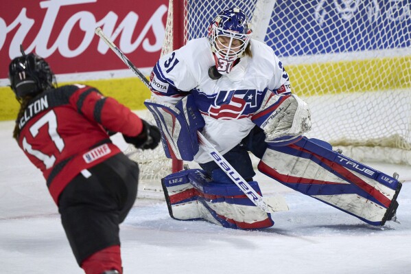 U.S. goaltender Aerin Frankel makes a save on Canada's Ella Shelton during a Rivalry Series hockey game in Kitchener, Ontario, Thursday, Dec. 14, 2023. (Geoff Robins/The Canadian Press via AP)