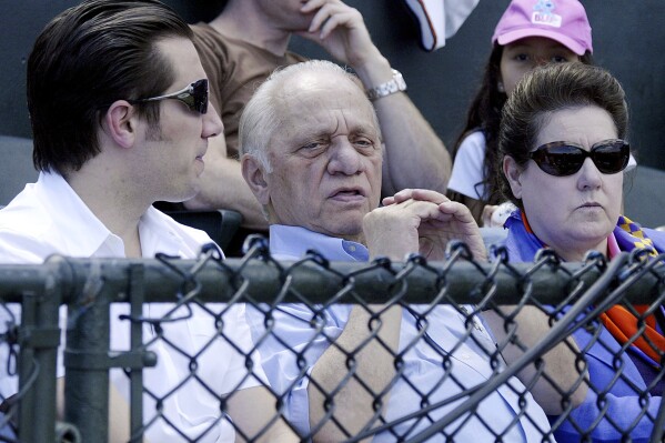 FILE - Peter G. Angelos, center, owner of the Baltimore Orioles, sits in the owners box at Ft.Lauderdale Stadium in Ft. Lauderdale, Fla. with his son, Louis, and wife, Georgia, during his team's spring training baseball game against the Boston Red Sox Sunday, March 18, 2007. Peter Angelos, owner of a Baltimore Orioles team that endured long losing stretches and shrewd proprietor of a law firm that won high-profile cases against industry titans, died Saturday, March 23, 2024. He was 94. (AP Photo/James A. Finley, File)