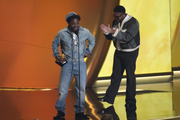 Kendrick Lamar, left, accepts the record of the year award for "Not Like Us during the 67th annual Grammy Awards on Sunday, Feb. 2, 2025, in Los Angeles. Mustard looks on from right. (AP Photo/Chris Pizzello)