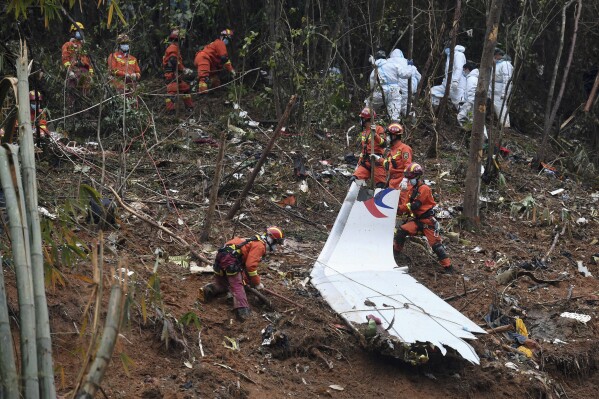 FILE - In this photo released by Xinhua News Agency, search and rescue workers search through debris at the China Eastern flight crash site in Tengxian County in southern China's Guangxi Zhuang Autonomous Region on March 24, 2022. Two years after a Boeing 737-800 passenger jet crashed on a domestic flight in China, killing all 132 people on board, accident investigators indicated Wednesday, March 20, 2024 that they have not yet determined the cause. (Lu Boan/Xinhua via AP, File)