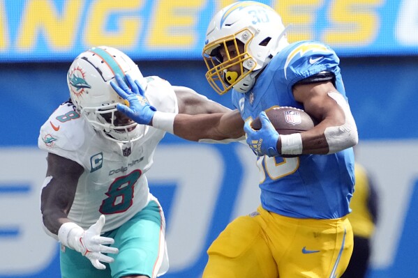 Los Angeles Chargers running back Austin Ekeler (30) stiff-arms Miami Dolphins safety Jevon Holland (8) during the first half of an NFL football game Sunday, Sept. 10, 2023, in Inglewood, Calif. (AP Photo/Mark J. Terrill)
