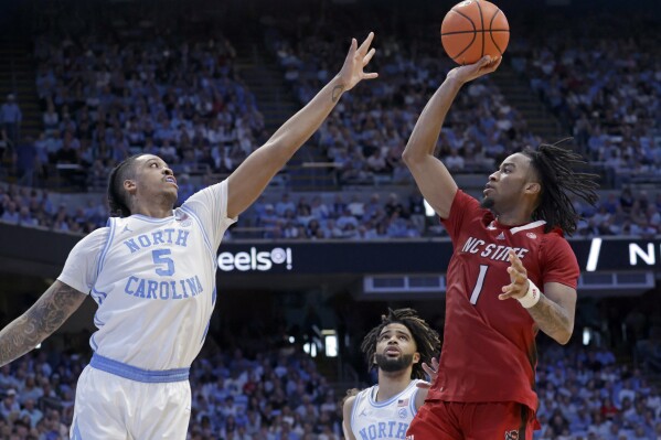 North Carolina State guard Jayden Taylor (1) shoots over North Carolina forward Armando Bacot (5) during the second half of an NCAA college basketball game Saturday, March. 2, 2024, in Chapel Hill, N.C. (AP Photo/Chris Seward)