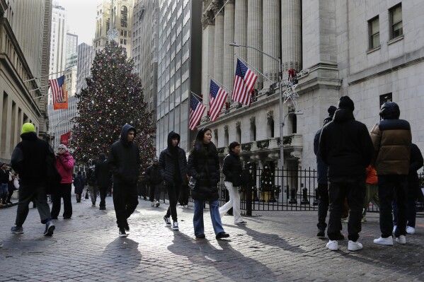 Pedestrians pass the New York Stock Exchange on Tuesday, Jan. 2, 2024 in New York. The S&P 500 was lower in midday trading after pulling to the brink of its all-time high set roughly two years ago. (AP Photo/Peter Morgan)