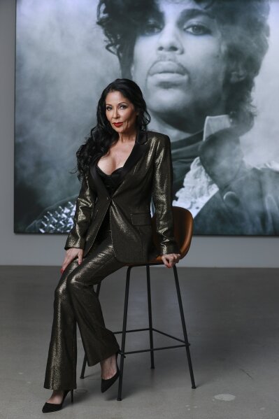 Apollonia Kotero, a former protege and longtime friend of Prince, poses in front of a portrait of the artist at Warner Music Group in Los Angeles on Friday, May 31, 2019. Kotero said Prince's untimely death in 2016 sent her into a “rabbit hole of severe depression.” (Photo by Mark Von Holden/Invision/AP)
