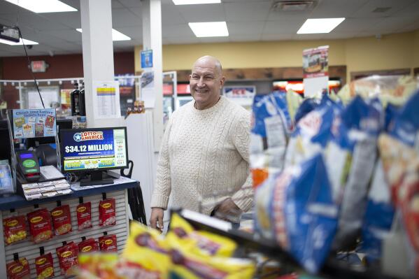 Hometown Gas & Grill owner Fred Cotreau greets customers on Saturday morning, Jan. 14, 2023, in Lebanon, Maine. A Mega Millions ticket purchased in the York County town of Lebanon, Maine, that was sold at the store matched the winning numbers for Friday night's estimated $1.35 billion grand prize. "We are anxiously awaiting the winner to be revealed," Cotreau explained to the many questions from patrons regarding who the winner is. (Derek Davis/Portland Press Herald via AP)