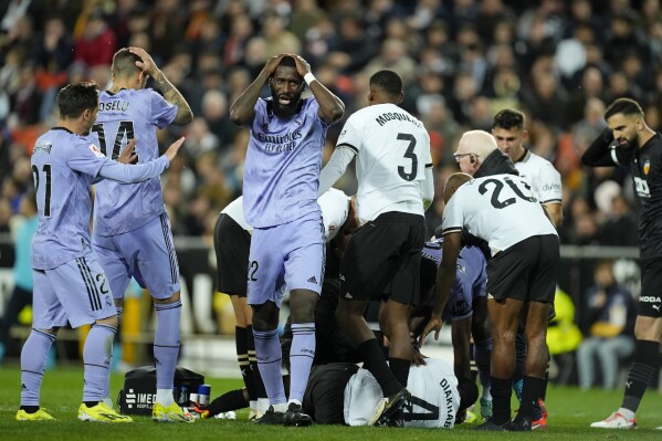 Real Madrid's Antonio Rudiger, center, reacts after Valencia's Mouctar Diakhaby receives treatment after getting an injury during the La Liga soccer match between Valencia and Real Madrid at the Mestalla Stadium in Valencia, Spain, Saturday, March 2, 2024. (AP Photo/Jose Breton)