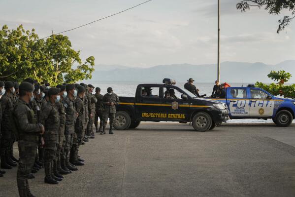 Soldiers receive instructions in El Estor, at the northern coastal province of Izabal, Guatemala, Sunday, Oct. 24, 2021. The Guatemalan government has declared a month-long, dawn-to-dusk curfew and banned pubic gatherings following two days of protests against a mining project. (AP Photo/Moises Castillo)