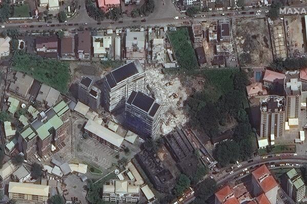 This satellite image provided by Maxar Technologies shows the close up of a collapsed building, center, in Lagos, Nigeria on Wednesday, Nov. 3, 2021. The 21-story luxury apartment building under construction toppled Monday and it took several hours for officials to launch the rescue effort. Authorities have arrested the property's owner, according to media reports, saying that his building permit only allowed for a 15-story structure. (Satellite image ©2021 Maxar Technologies via AP)