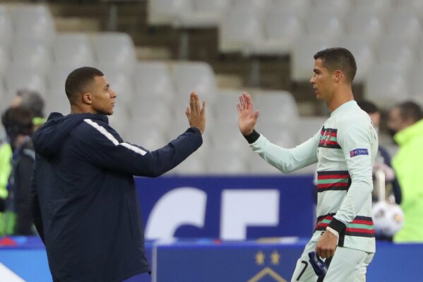 FILE - In this Sunday, Oct. 11, 2020 file photo France's Kylian Mbappe and Portugal's Cristiano Ronaldo, right, greet each other before the UEFA Nations League soccer match between France and Portugal at the Stade de France in Saint-Denis, north of Paris, France. The Portuguese soccer federation says Cristiano Ronaldo has tested positive for the coronavirus. The federation says Ronaldo is doing well and has no symptoms. He has been dropped from the country's Nations League match against Sweden on Wednesday. (AP Photo/Thibault Camus, File)