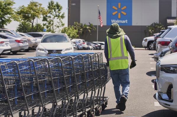 Empty shopping carts are collected from the parking lot at Walmart store in Burbank, Calif., on Thursday, April 10, 2025. (AP Photo/Damian Dovarganes, File)