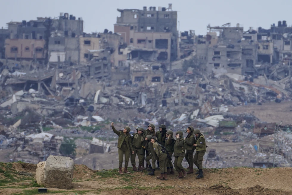 Israeli female soldiers pose for a photo on a position on the Gaza Strip border, in southern Israel, Monday, Feb. 19, 2024. (AP Photo/Tsafrir Abayov)