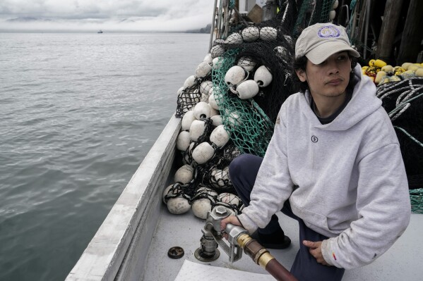 Juan Zuniga, a first-year deckhand on the Agnes Sabine, refuels the boat, Friday, June 23, 2023, in Kodiak, Alaska. For some young people who make the move to Alaska's coasts, the industry is a way to make quick money, but not a forever job. “This is a pretty far place from where I live,” Zuniga said. “It’s a very big step out of my comfort zone." (AP Photo/Joshua A. Bickel)