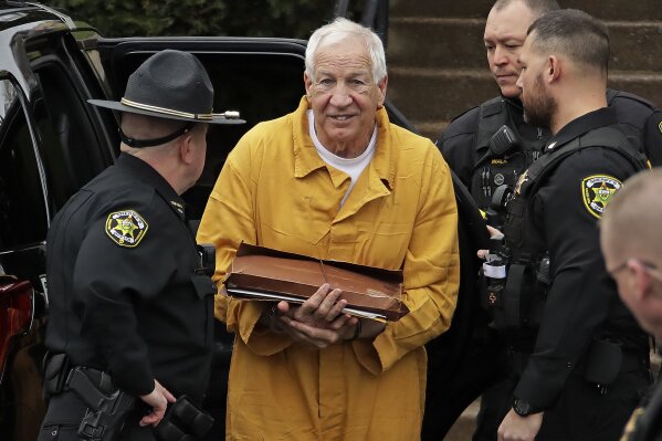 Former Penn State University assistant football coach Jerry Sandusky, center, arrives at the Centre County Courthouse to be resentenced Friday, Nov. 22, 2019, in Bellefonte, Pa. Sandusky was convicted of 45 counts of child sexual abuse in 2012 and sentenced to 30 to 60 years. (AP Photo/Gene J. Puskar)