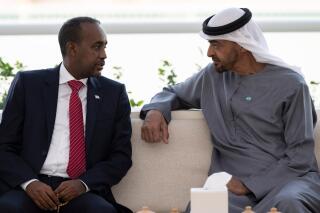 In this photo released by the state-run WAM news agency, Abu Dhabi's powerful crown prince, Sheikh Mohammed bin Zayed Al Nahyan, right, meets with Somali Prime Minister Mohammed Hussein Roble in Abu Dhabi, United Arab Emirates, Tuesday, Feb. 1, 2022. The United Arab Emirates late Tuesday welcomed the prime minister of Somalia's public apology for a Somali operation in 2018 that resulted in the seizure of Emirati aircraft and $9.6 million in cash, wrecking relations between the nations. (Hamad Al Kaabi/Ministry of Presidential Affairs/WAM via AP)​