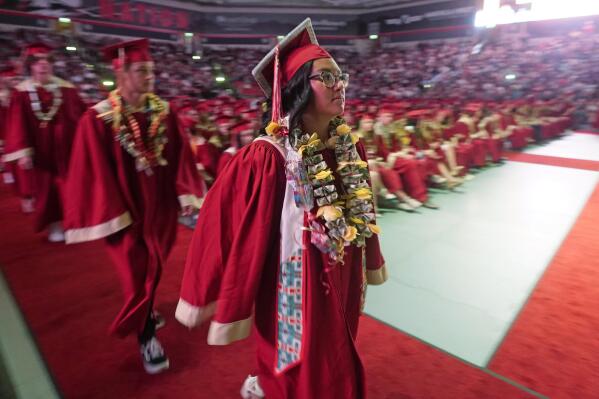 FILE - Amryn Tom graduates from Cedar City High School on Wednesday, May 25, 2022, in Cedar City, Utah. Tom is wearing an eagle feather given to her by her mother and a cap that a family friend beaded. (AP Photo/Rick Bowmer, File)