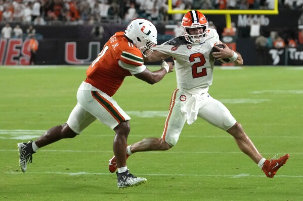 Miami linebacker Corey Flagg Jr. (11) prepares to tackle Clemson quarterback Cade Klubnik (2) on a game-ending play in double overtime of an NCAA college football game, Sunday, Oct. 22, 2023, in Miami Gardens, Fla. (AP Photo/Lynne Sladky)